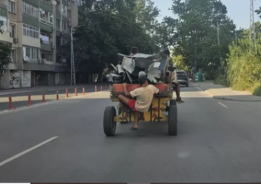 Каруца мина по натоварен булевард с дете, буквално висящо отвън