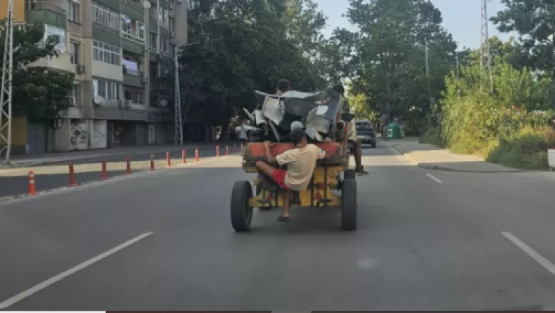 Каруца мина по натоварен булевард с дете, буквално висящо отвън